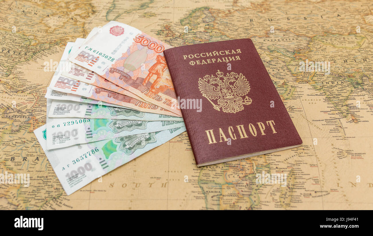 Passaporto russo con il denaro entro sulla mappa del mondo close up Foto Stock