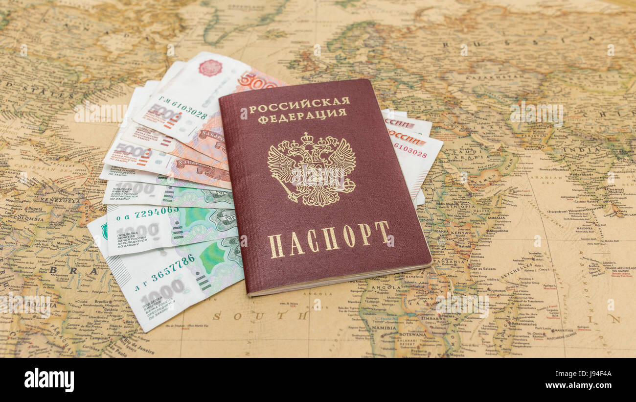 Passaporto russo con il denaro entro sulla mappa del mondo close up Foto Stock