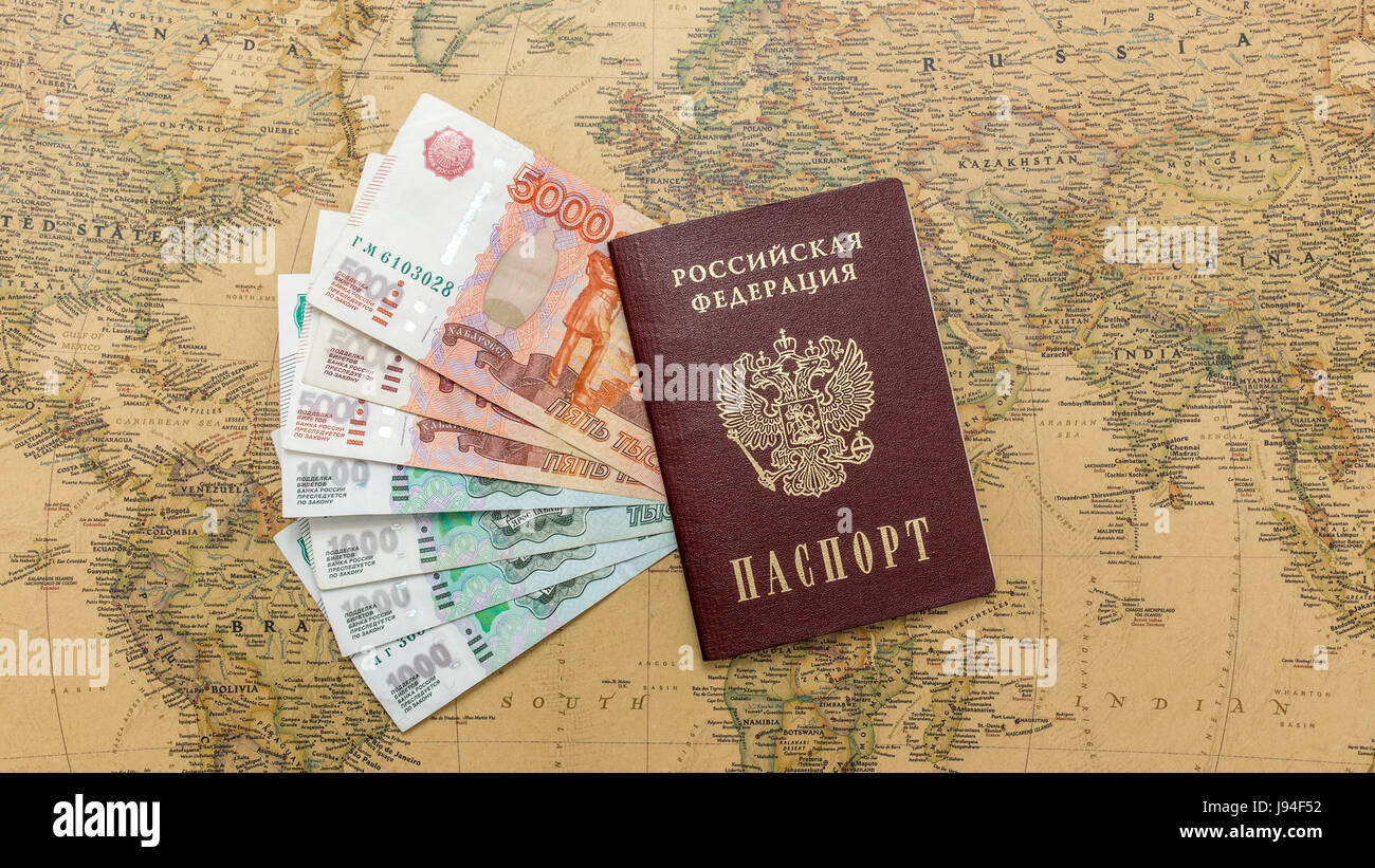 Passaporto russo con il denaro entro sulla mappa del mondo close up Foto Stock