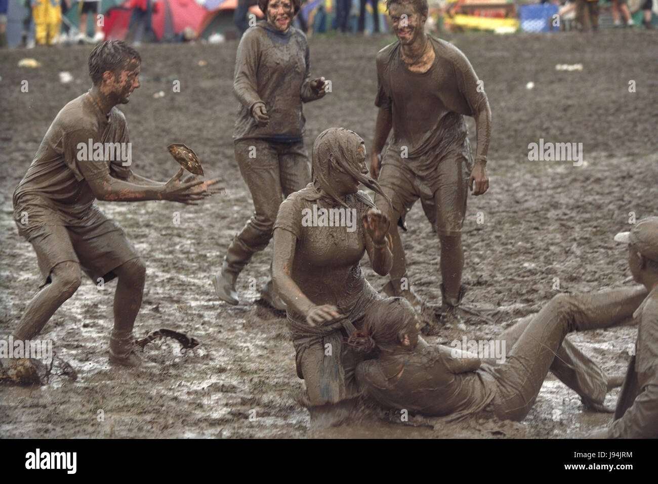 Glastonbury Festival 1998, uno degli anni peggiori per fanghi, dove i partecipanti del festival è andato a fango di balneazione tra guardare la musica dal vivo di atti. Il festival annuale attira fino a 175.000 persone per azienda agricola degna dove si può guardare spettacoli di musica dal vivo su numerosi stadi comprende la fase della piramide. Foto Stock