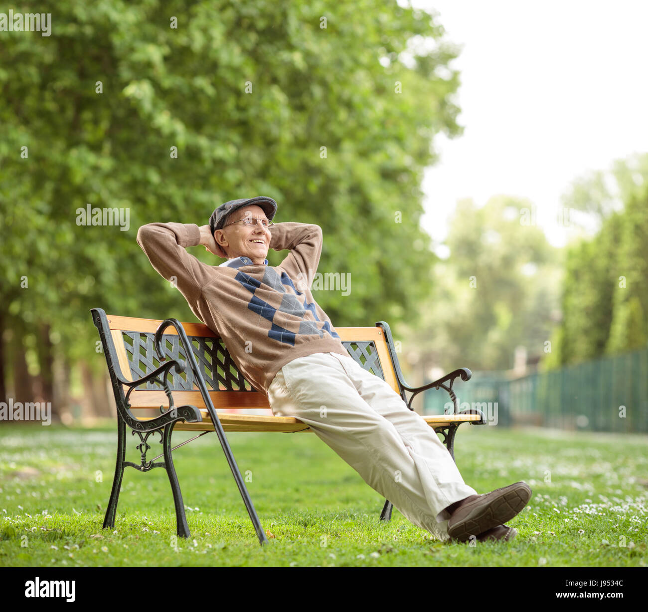 Senior relax su una panca in legno nel parco Foto Stock