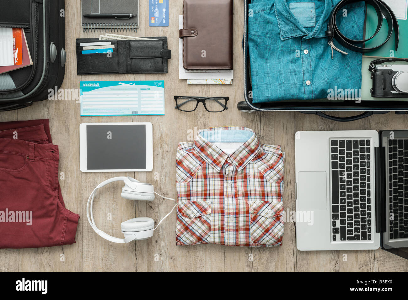 Pronti per un viaggio e imballaggio una valigia prima di lasciare;  accessori, abbigliamento e oggetti personali su un desktop, viaggi e  vacanze concept Foto stock - Alamy