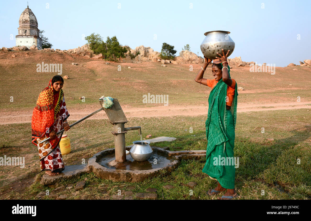 Le donne tribali rurali stanno trasportando il pipelino dell'acqua per raccogliere l'acqua potabile in un villaggio remoto dell'India. Foto Stock