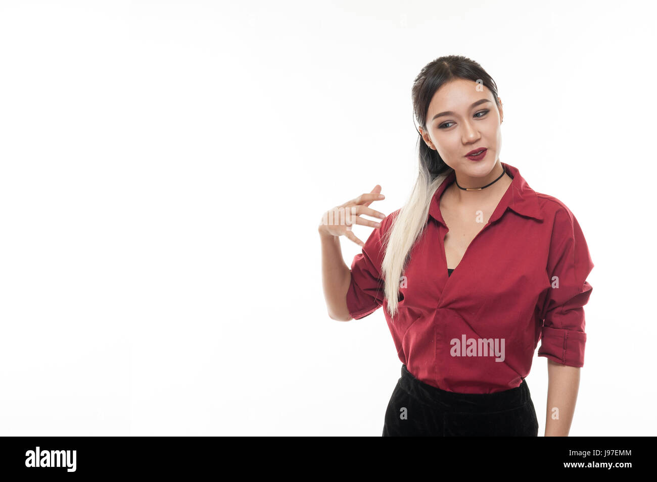 Giovani attraenti tan pelle donna asiatica indossare maglietta rossa in buona sensazione di azione. Studio scena di donna con emozione positiva con spazio di copia Foto Stock