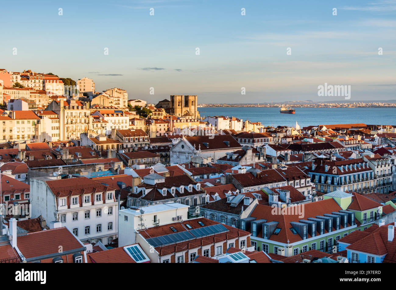 Tetti di Baixa, il centro storico di Lisbona, con il fiume Tago e il Motherchurch sullo sfondo, al crepuscolo. Lisbona, Portogallo Foto Stock