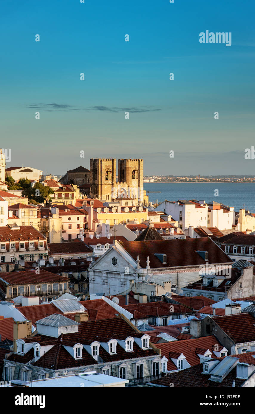 Tetti di Baixa, il centro storico di Lisbona, con il fiume Tago e il Motherchurch sullo sfondo, al crepuscolo. Lisbona, Portogallo Foto Stock