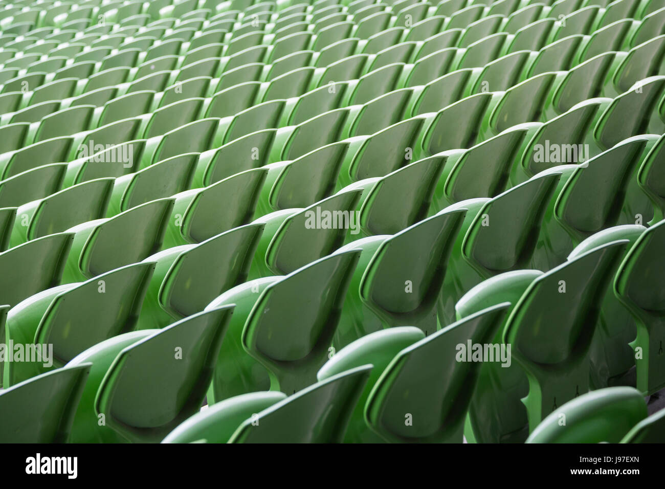 Una fila di vuoto sedili verde in uno stadio di calcio Foto Stock