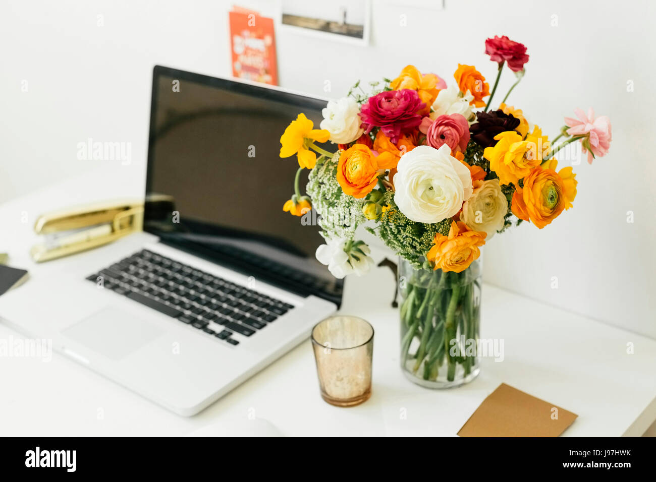 Fiori in vaso vicino al computer portatile in ufficio Foto stock - Alamy