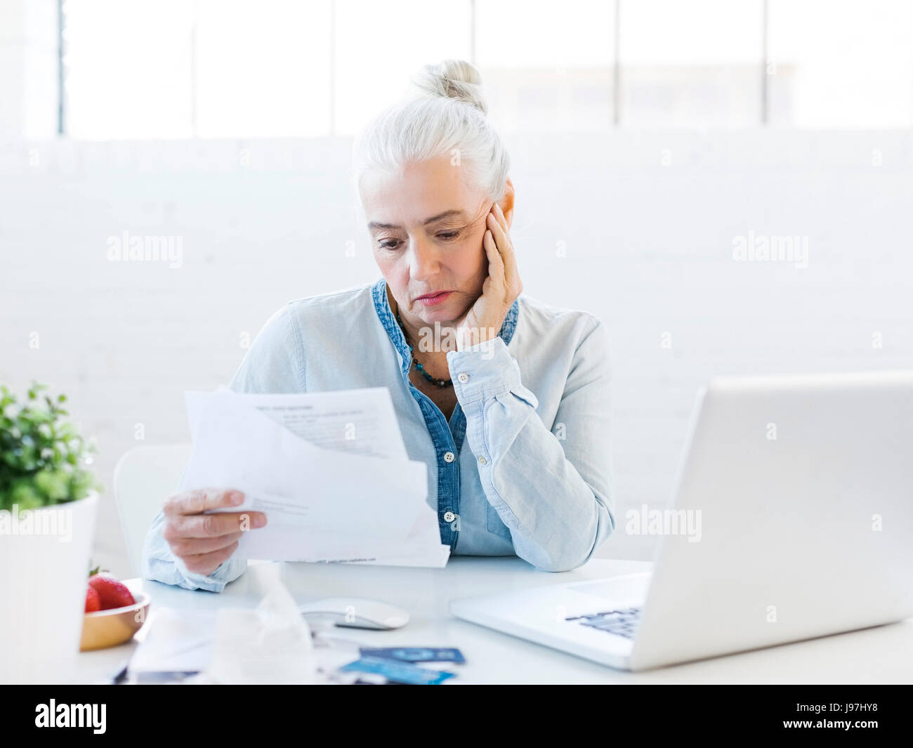 Senior donna il pagamento di fatture Foto Stock