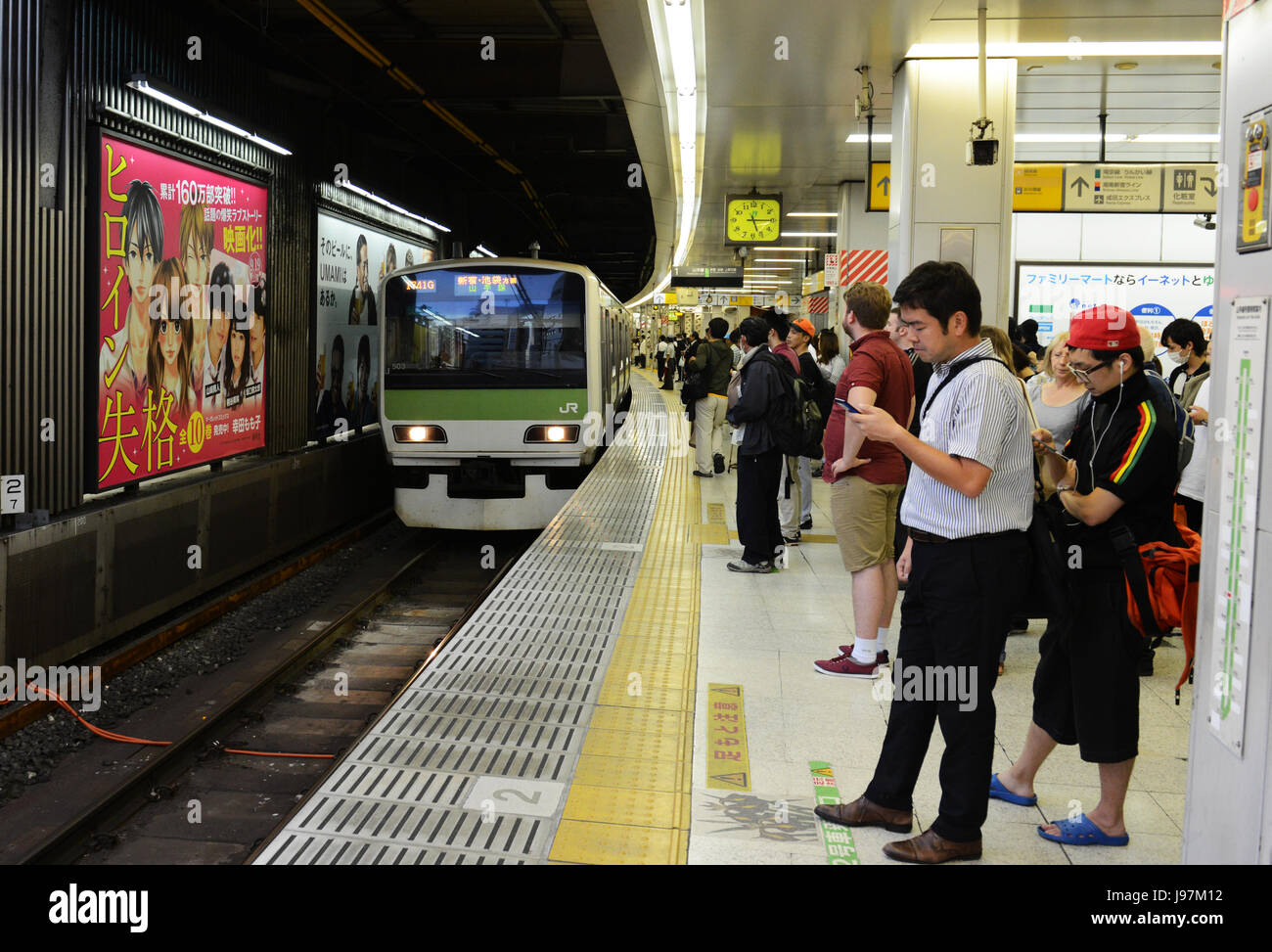 I passeggeri in attesa per la linea Yamanote treno in Tokyo. Foto Stock