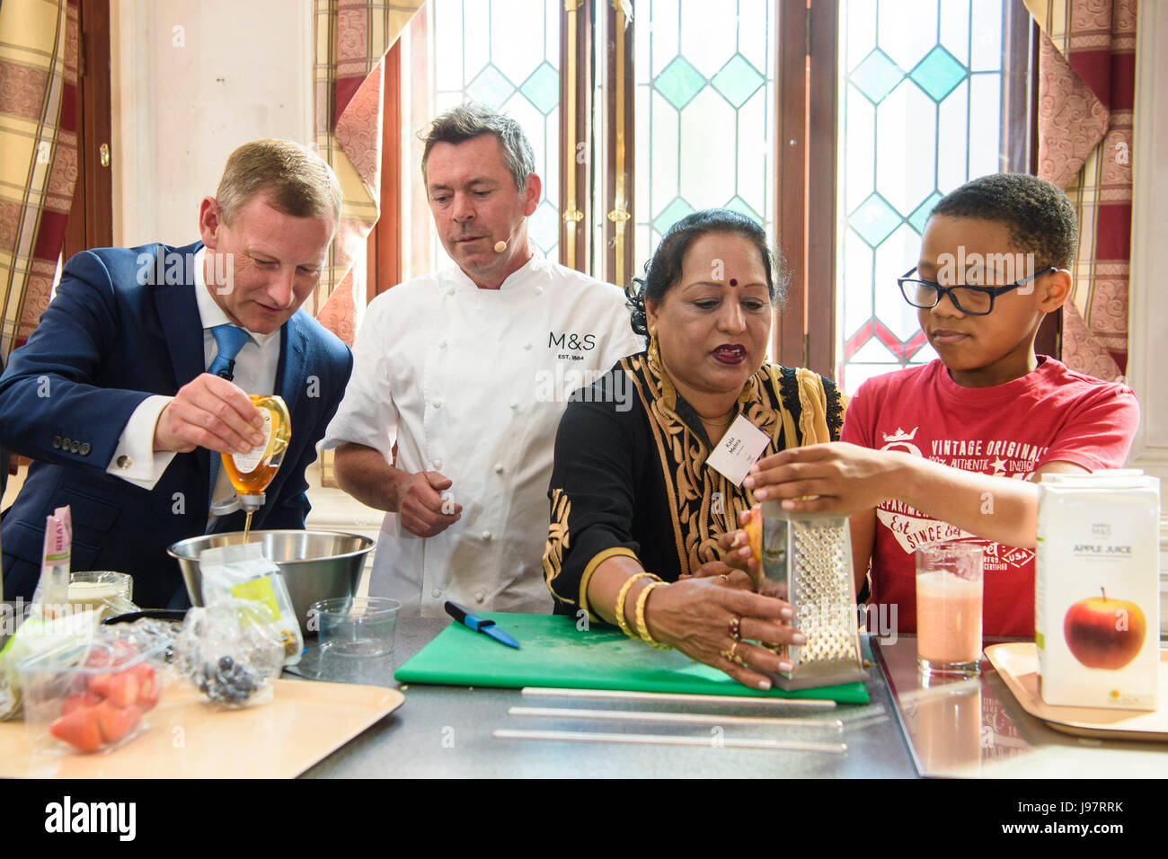 (L-R) M&S CEO Steve Rowe a fianco di chef Adam Palmer e residenti a Newham Kala Mehri e Shakir, di età compresa tra i 8, preparare una colazione fatta con eccedenze alimentari, in occasione del lancio di M&S La nuova comunità programma di trasformazione, a Stratford Vecchio Municipio nella zona est di Londra. Stampa foto di associazione. Picture Data: giovedì 1 giugno, 2017. Il vasto programma includeranno il sostegno per gli scolari di beneficenza e le persone anziane con un obiettivo di supportare 1000 europee entro il 2025. Foto Stock