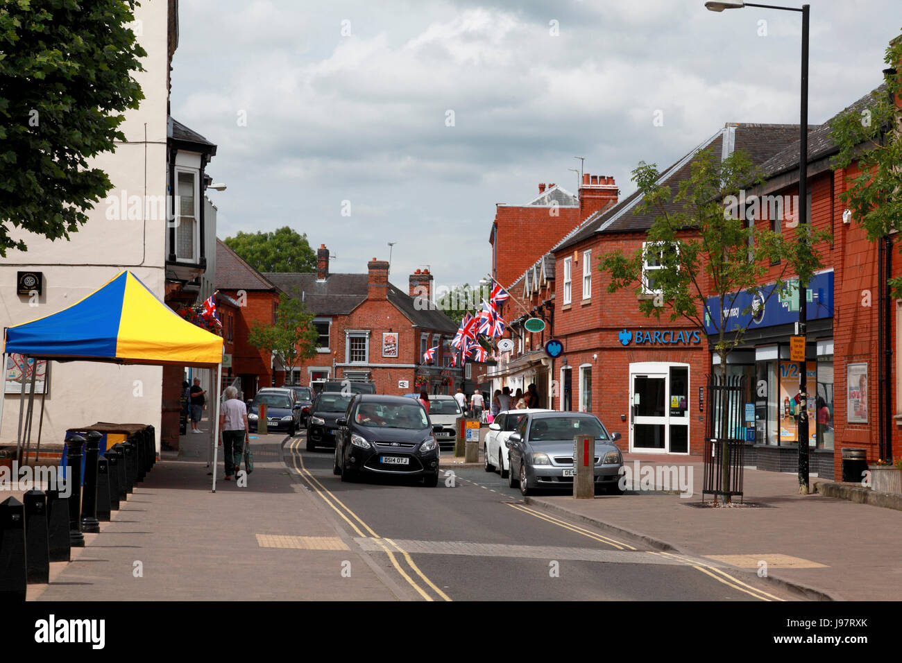 La strada principale di Market Drayton, con un senso di traffico, ampi marciapiedi, parcheggio sosta breve e doppie linee di colore giallo Foto Stock