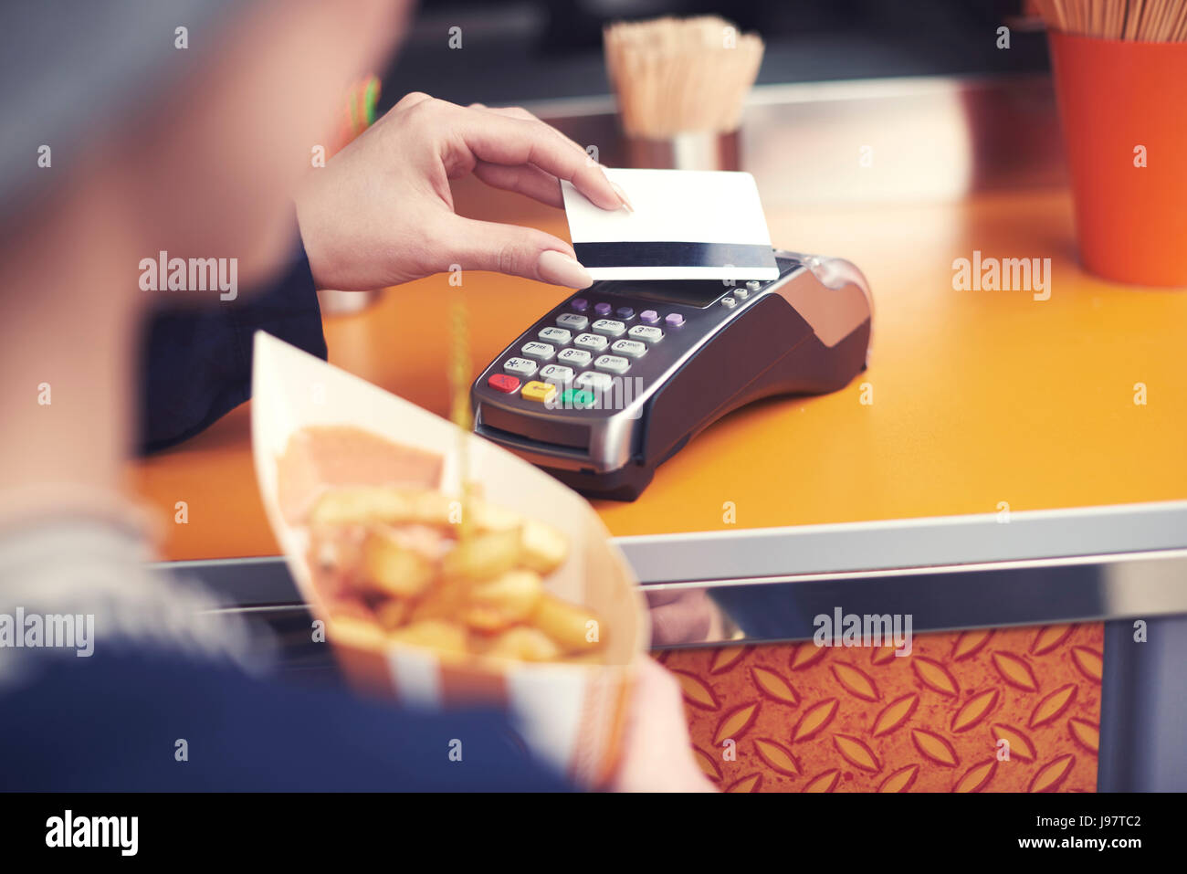 Donna di pagare per il cibo malsano con carta di credito Foto Stock