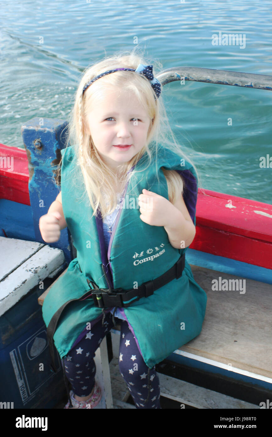 Bambino di indossare un giubbotto di salvataggio,avendo divertimento su un viaggio in barca nella baia di Dublino, Irlanda Foto Stock