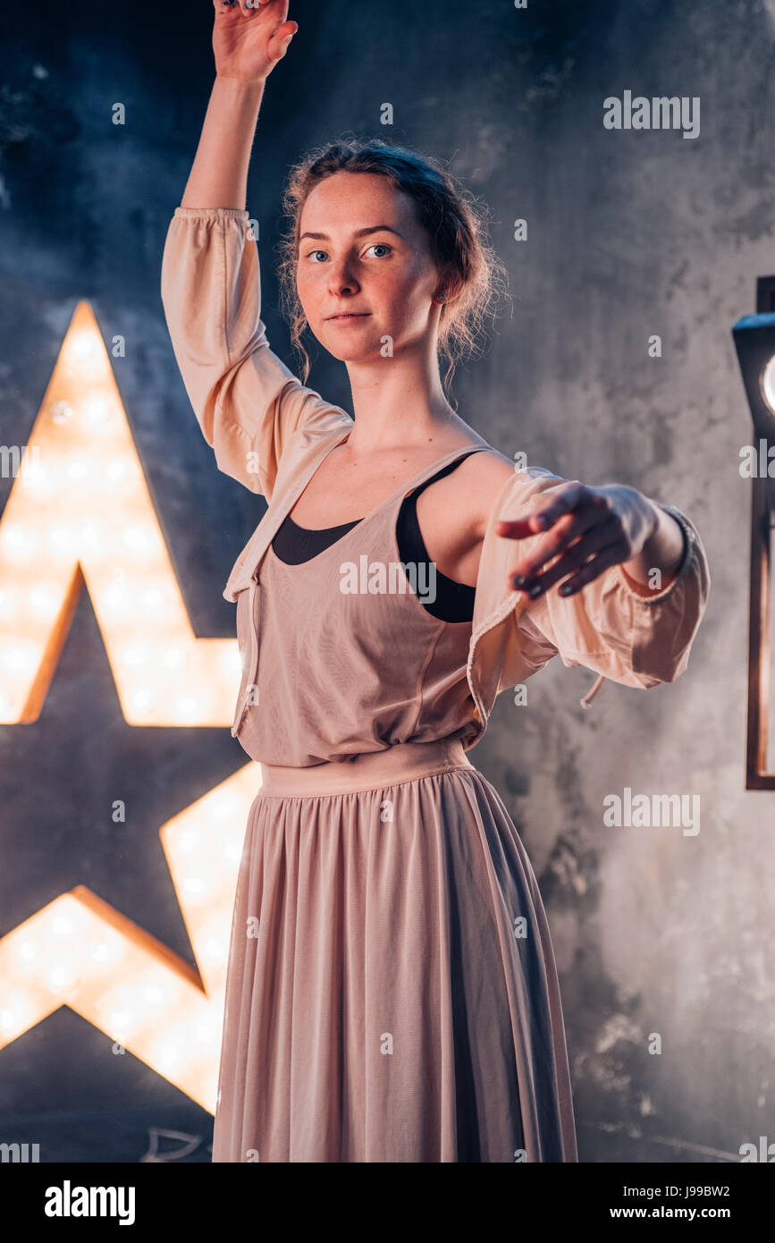 Ballerina esercitazione pratica di fronte una stella illuminata su un dak studio Foto Stock