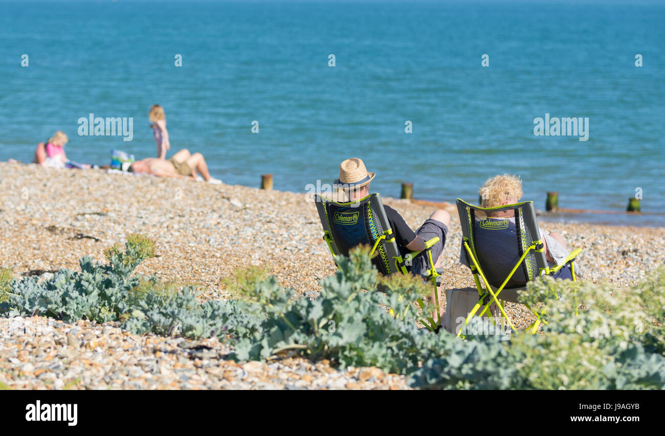 Persone che si oziano su una spiaggia in un caldo Summers giorno nel Regno Unito. Foto Stock