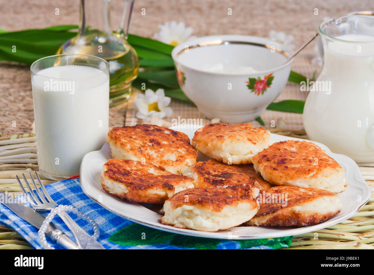 Cagliata fritti frittelle su un piatto da portata e latte Foto Stock