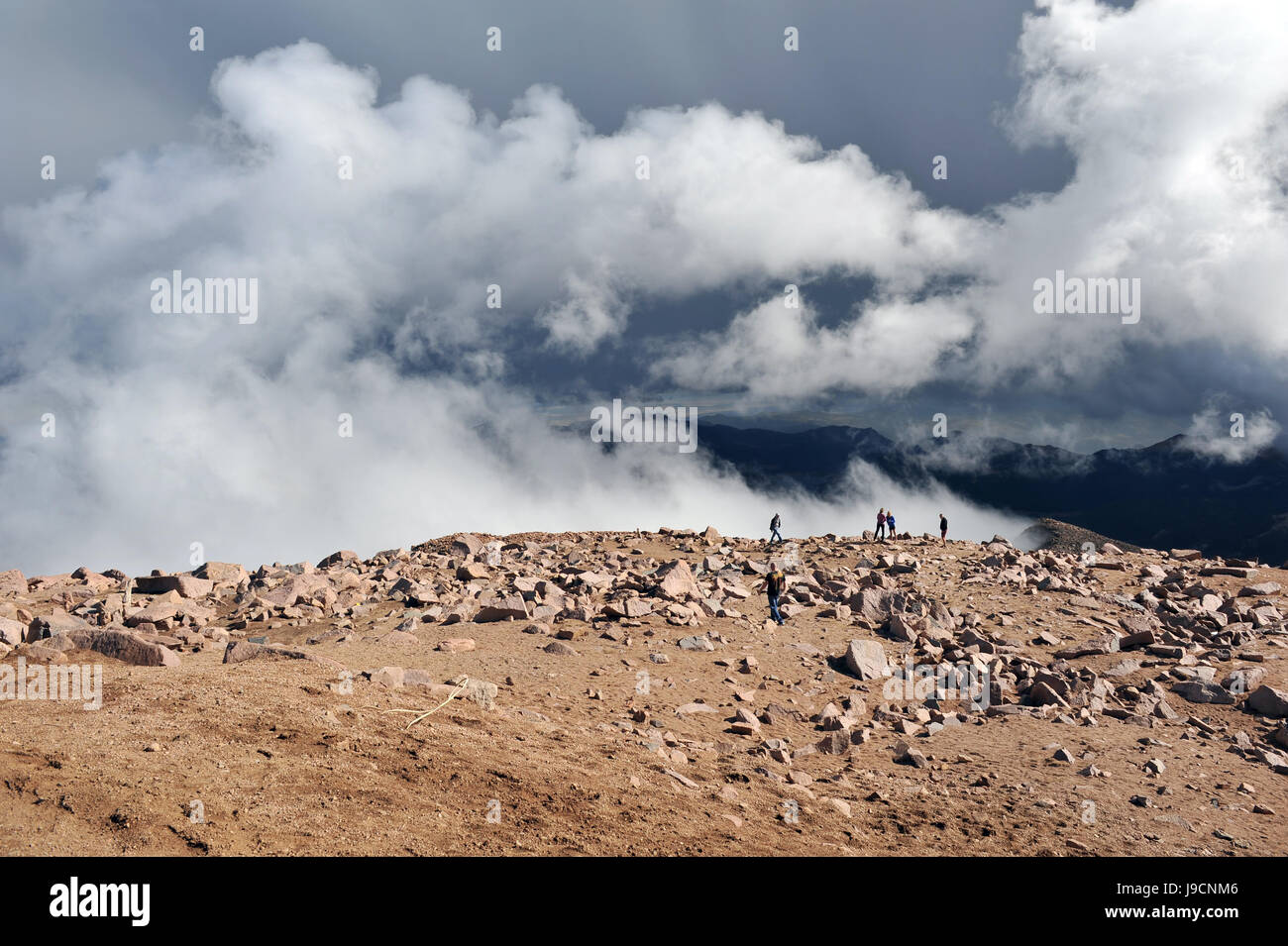 Nuvole salire dal di sotto il bordo della montagna su Pikes Peak Foto Stock