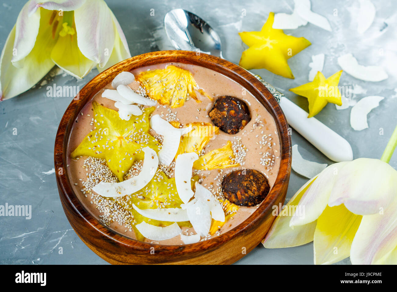 Frullato al cioccolato ciotola con frutti esotici e le sfere di energia. Amore per un sano cibo vegan concept Foto Stock