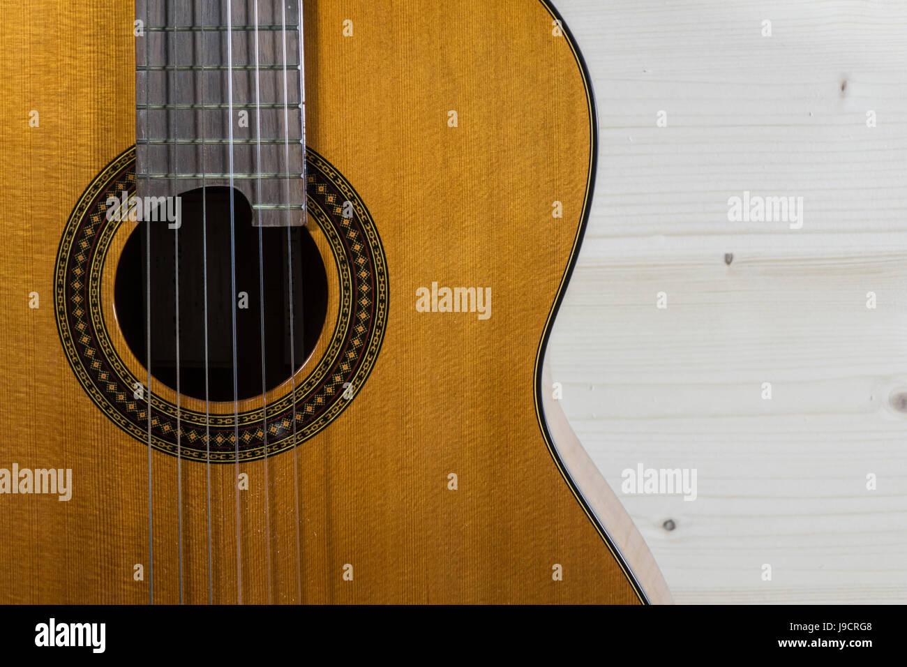Chitarra acustica classic in appoggio contro uno sfondo di legno con spazio di copia Foto Stock