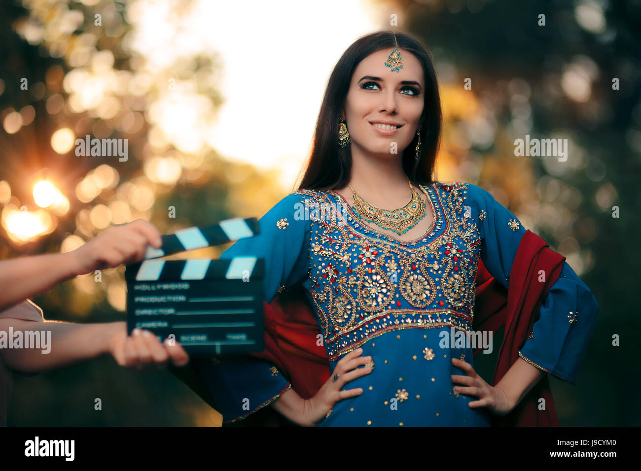 Bollywood attrice indossando un vestito indiano con oro e gioielli impostare Foto Stock