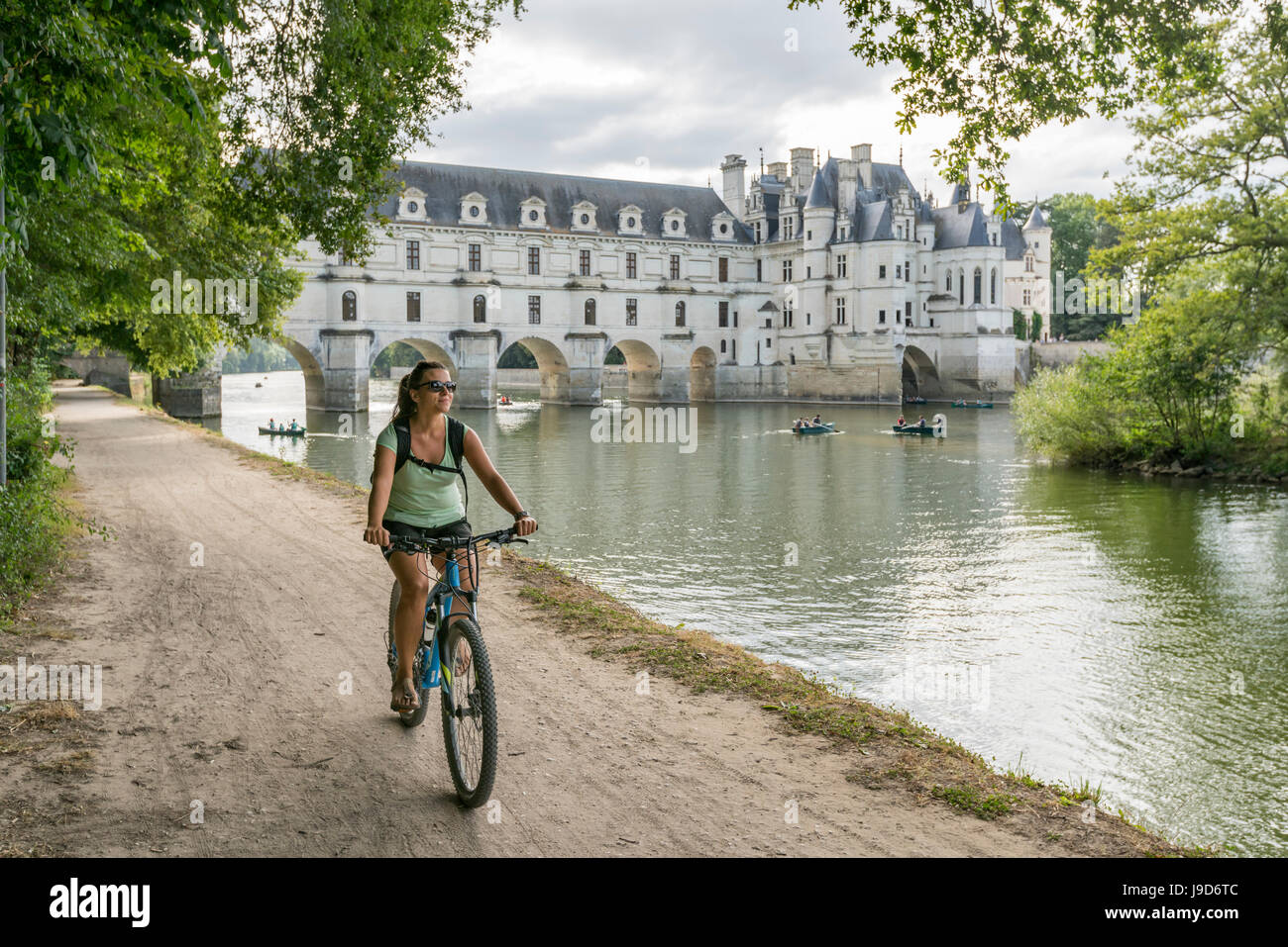 Ragazza in bicicletta con il castello di Chenonceau sullo sfondo, Sito Patrimonio Mondiale dell'UNESCO, Chenonceaux, Indre-et-Loire, centro, Francia Foto Stock
