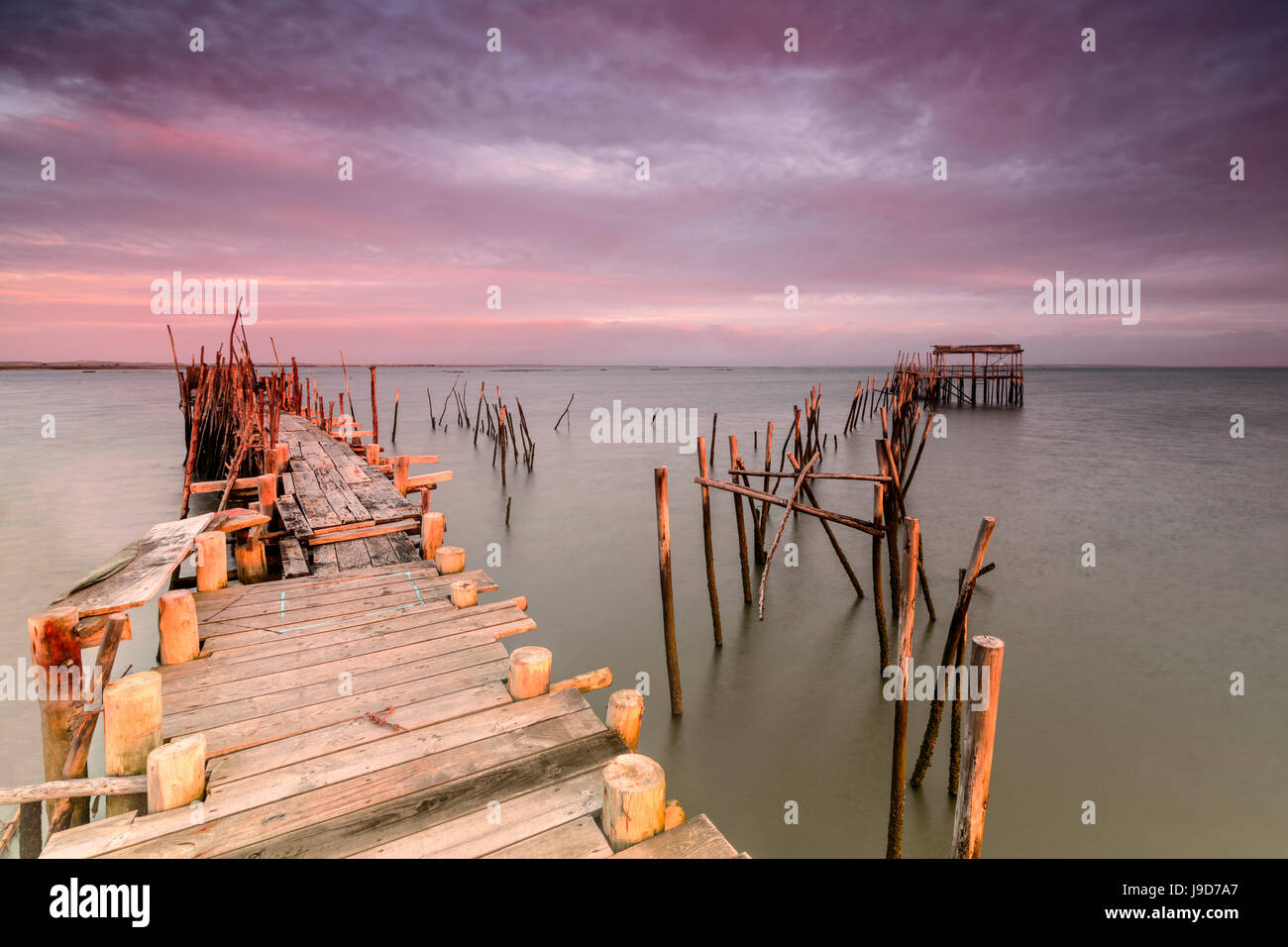 Cielo rosa all'alba sul molo Palafito nel Carrasqueira riserva naturale del fiume Sado, Alcacer do Sal, Setubal, Portogallo Foto Stock