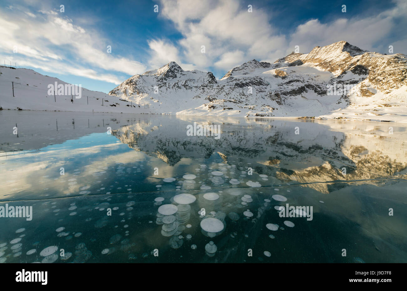 Bolle di ghiaccio telaio le cime innevate si riflette nel Lago Bianco, Passo Bernina del cantone dei Grigioni, Engadina, Svizzera, Europa Foto Stock