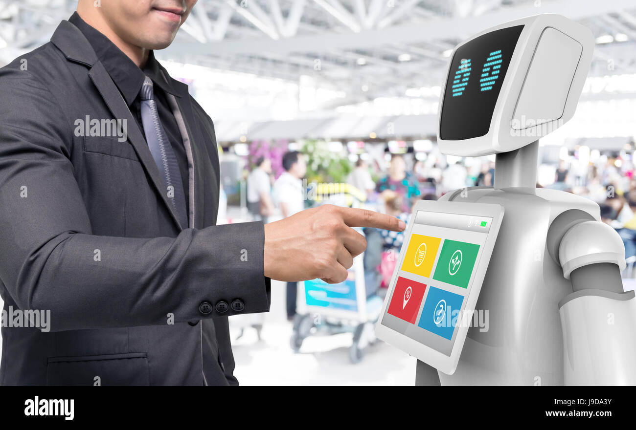 Robotics Tecnologia Tendenze concetto aziendale. Abito uomo punto dito per autonoma assistente personale robot per la navigazione in direzione aeroporto blur bac Foto Stock