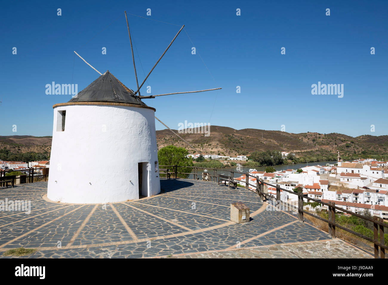 Mulino a vento al di sopra del villaggio di Rio e il fiume Guadiana con vista al Portogallo, Sanlucar De Guadiana, provincia di Huelva, Andalusia, Spagna Foto Stock