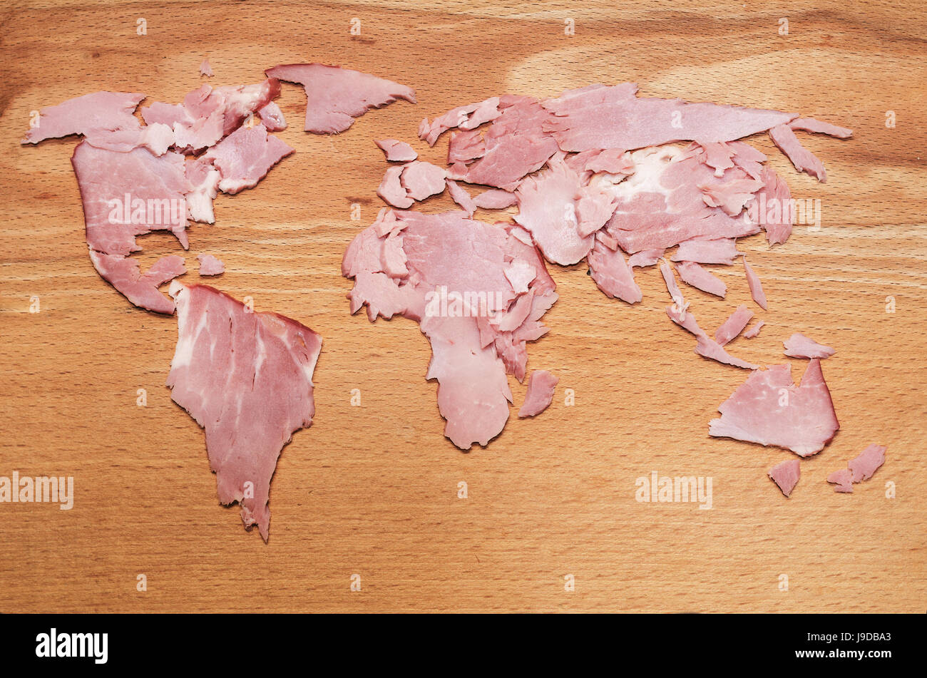 Mappa mondo realizzato da fette di carne su sfondo di legno Foto Stock