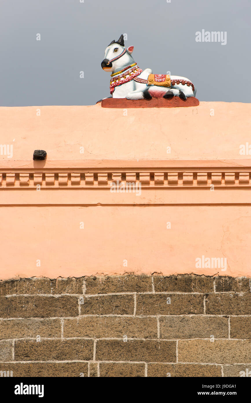 Una statuetta della divinità Nandy siede in cima alla parete perimetrale del tempio Arunachaleshwara a Tiruvannamalai, Tamil Nadu, India Foto Stock
