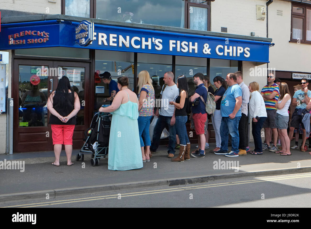 La gente in coda al di fuori del francese fish & chip shop, pozzi-next-il-mare del Nord di Norfolk, Inghilterra Foto Stock