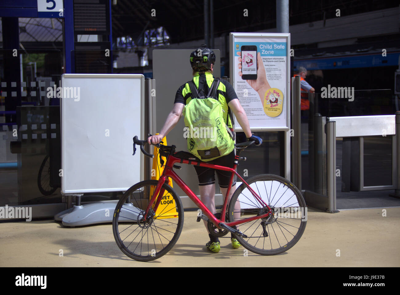 Ciclista a queen street stazione ferroviaria sotto il segno gaelico scotrail Foto Stock