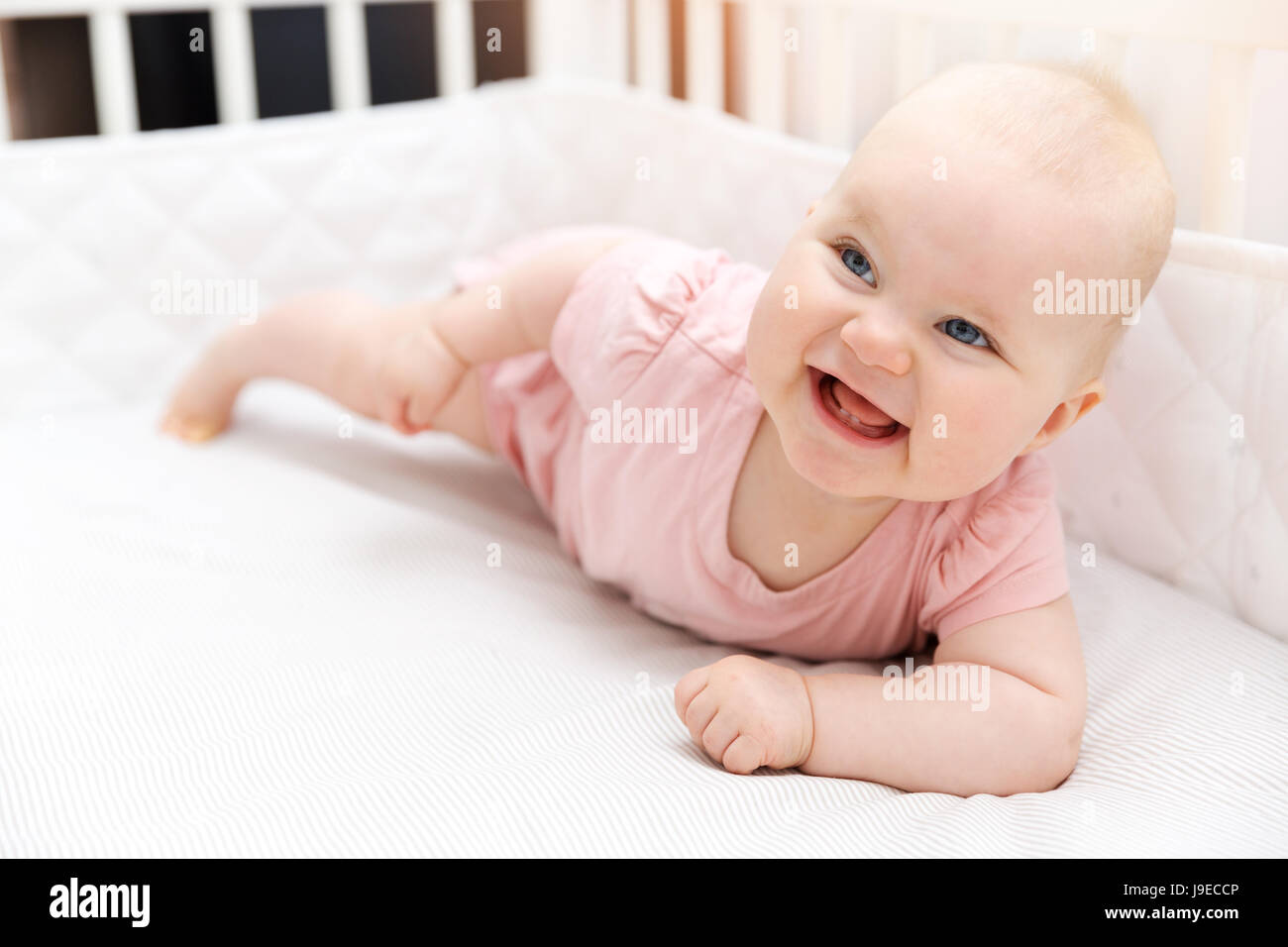 Felice sorridente bambina in culla Foto Stock