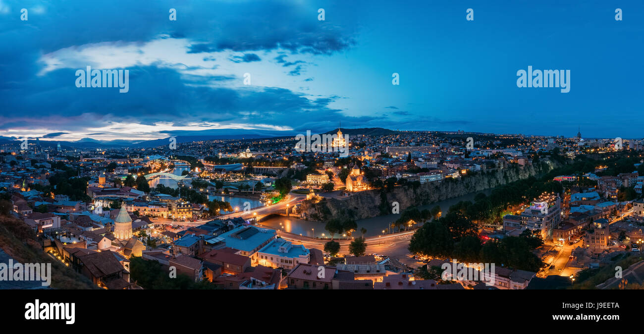 Tbilisi, Georgia. La Scenic panoramica Cima vista del paesaggio urbano in serata illuminazione brillante con tutti i famosi punti di riferimento e attrazioni in drammatico blu C Foto Stock