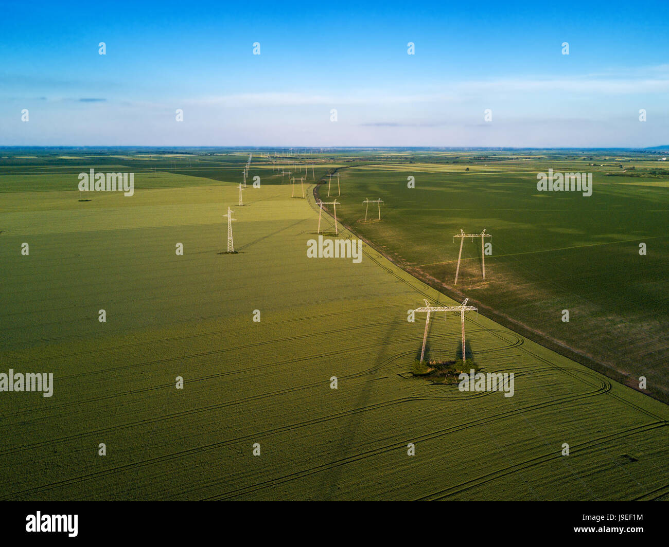 Vista aerea di overhead la linea elettrica di tralicci nel paesaggio di pianura Foto Stock