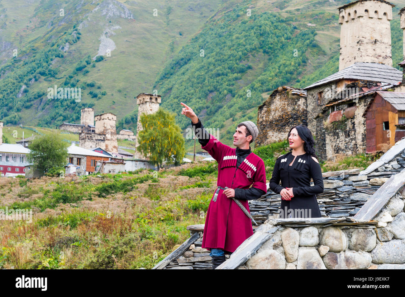 Georgian giovane da un gruppo folcloristico su un ponte di pietra di fronte Ushguli villaggio, per il solo uso editoriale, Ushguli, regione di Svaneti, Georgia Foto Stock