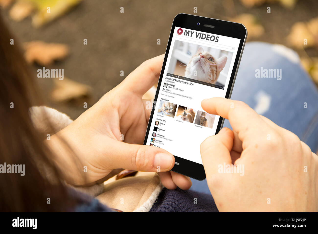 Mobile video concetto: donna tenendo un 3d generati smartphone con gatti video sullo schermo. La grafica sullo schermo sono costituiti. Foto Stock