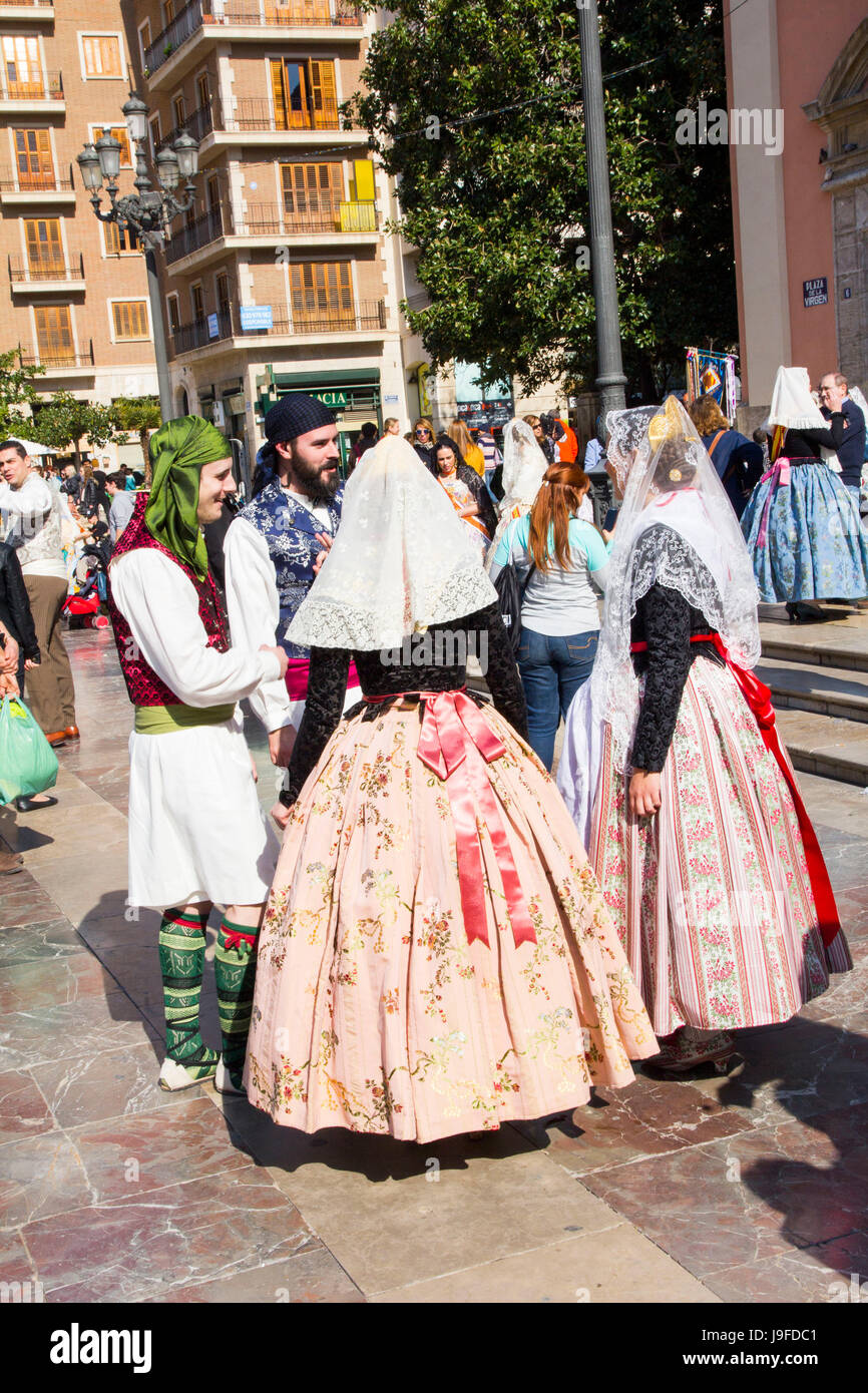 Durante una marcia annuale festival Las Fallas (incendi), migliaia di Falleras e Falleros affollano le strade di Valencia, Spagna vicino alla cattedrale. Foto Stock