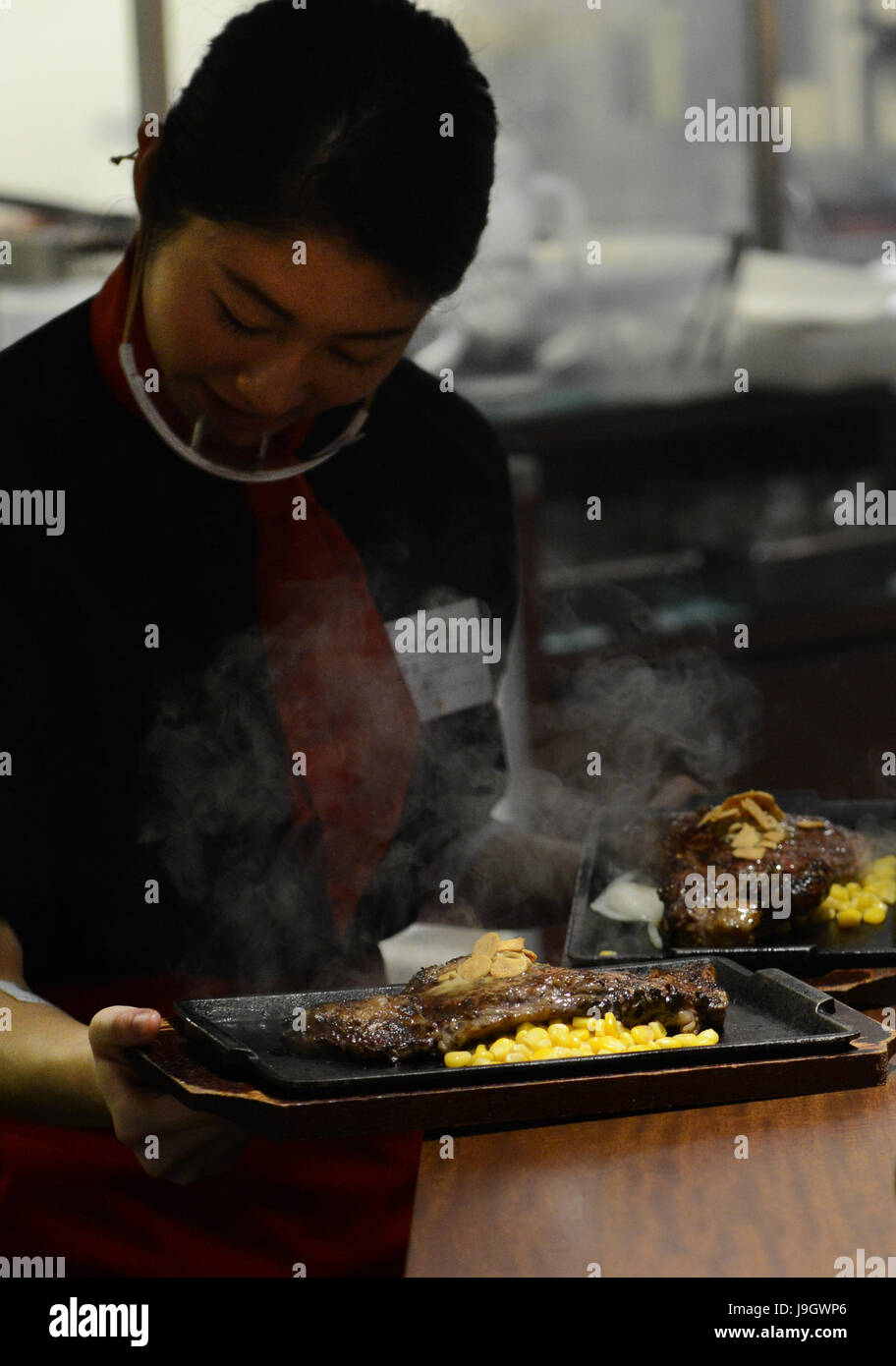 Un sfrigolanti bistecca alla griglia servite in una steakhouse giapponese a Tokyo. Foto Stock