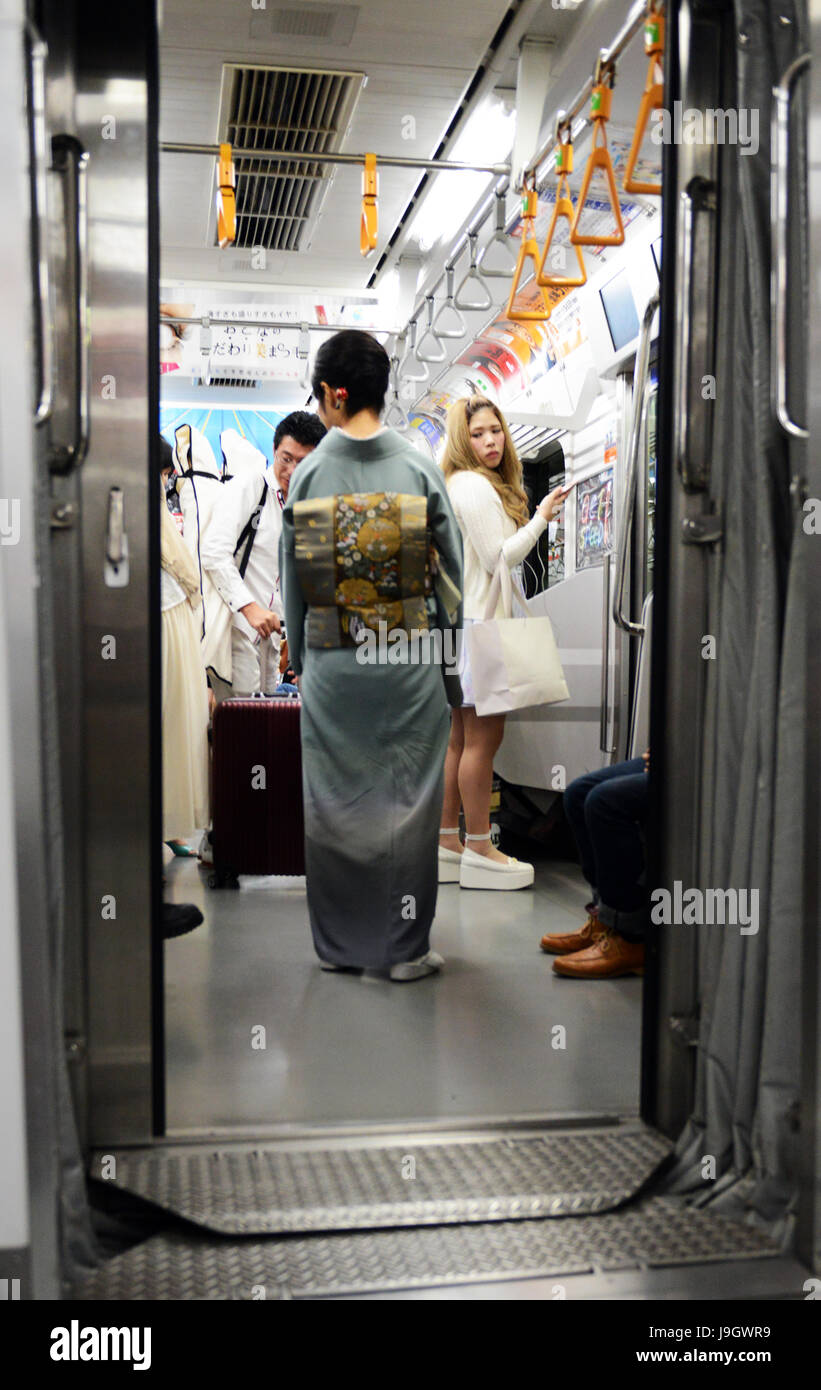 Una donna giapponese vestita in kimono in un metro / treno della metropolitana di Tokyo. Foto Stock
