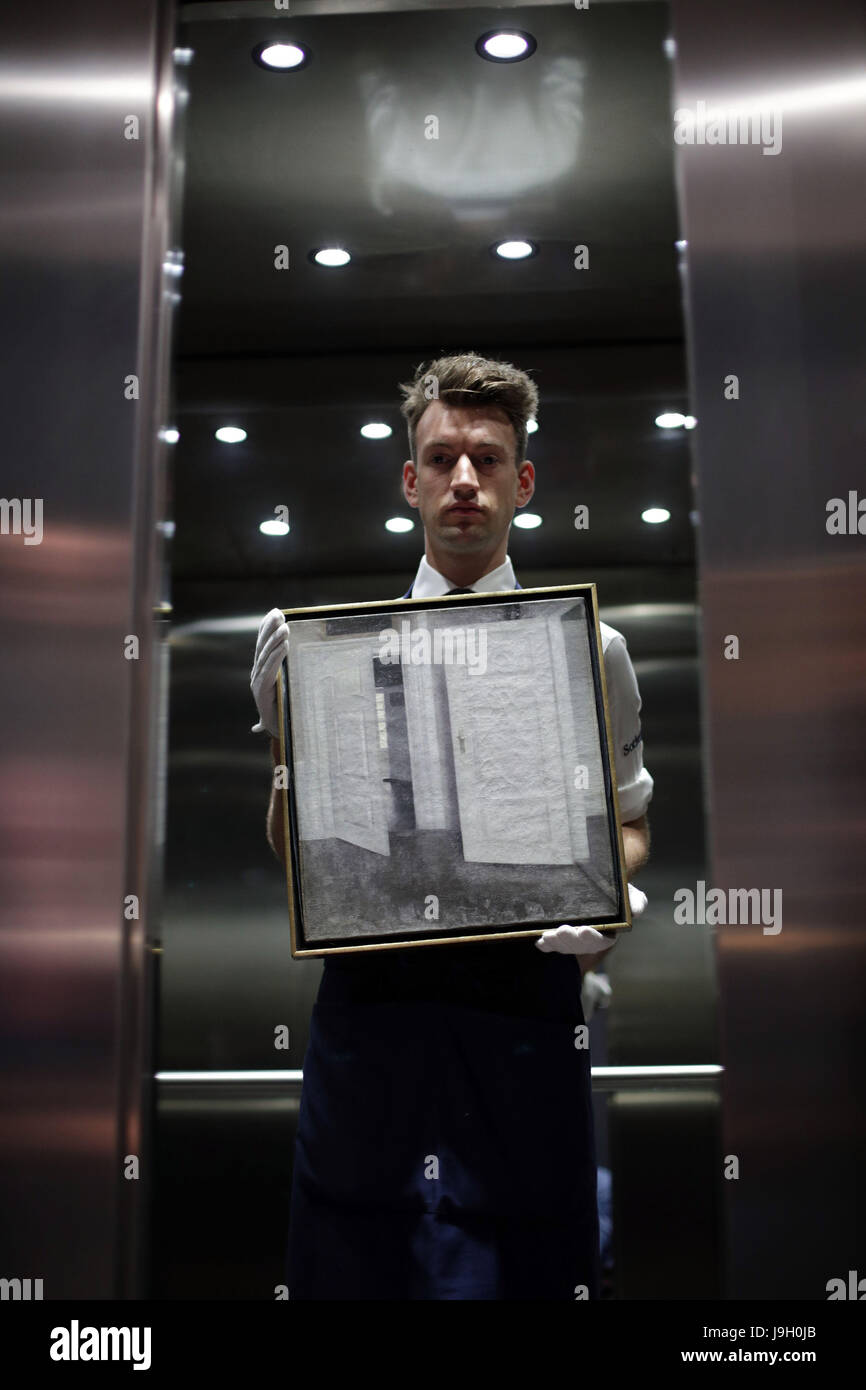 Un gestore di arte da Sotheby's a Londra detiene un Vilhelm Hammershoi pittura intitolato porte Bianco (1899) durante un'anteprima della casa d'asta le vendite di Arte Russa, Faberge e il XIX secolo dipinti europei entro questo mese. Foto Stock