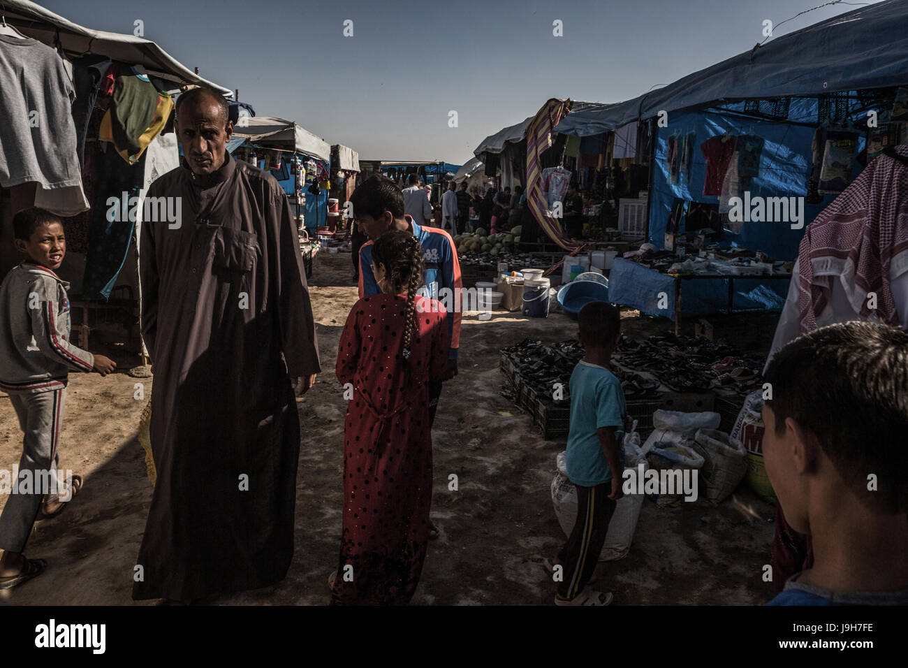 Di iracheni fuggiti durante i combattimenti tra l esercito iracheno e la milizia terroristica Stato islamico (SI) a piedi attraverso un mercato in un campo di rifugiati in Jed'ah, vicino a Mosul, Iraq, 01 giugno 2017. L'esercito iracheno spera di completamente libero il È-roccaforte presto. Foto: Andrea DiCenzo/dpa Foto Stock