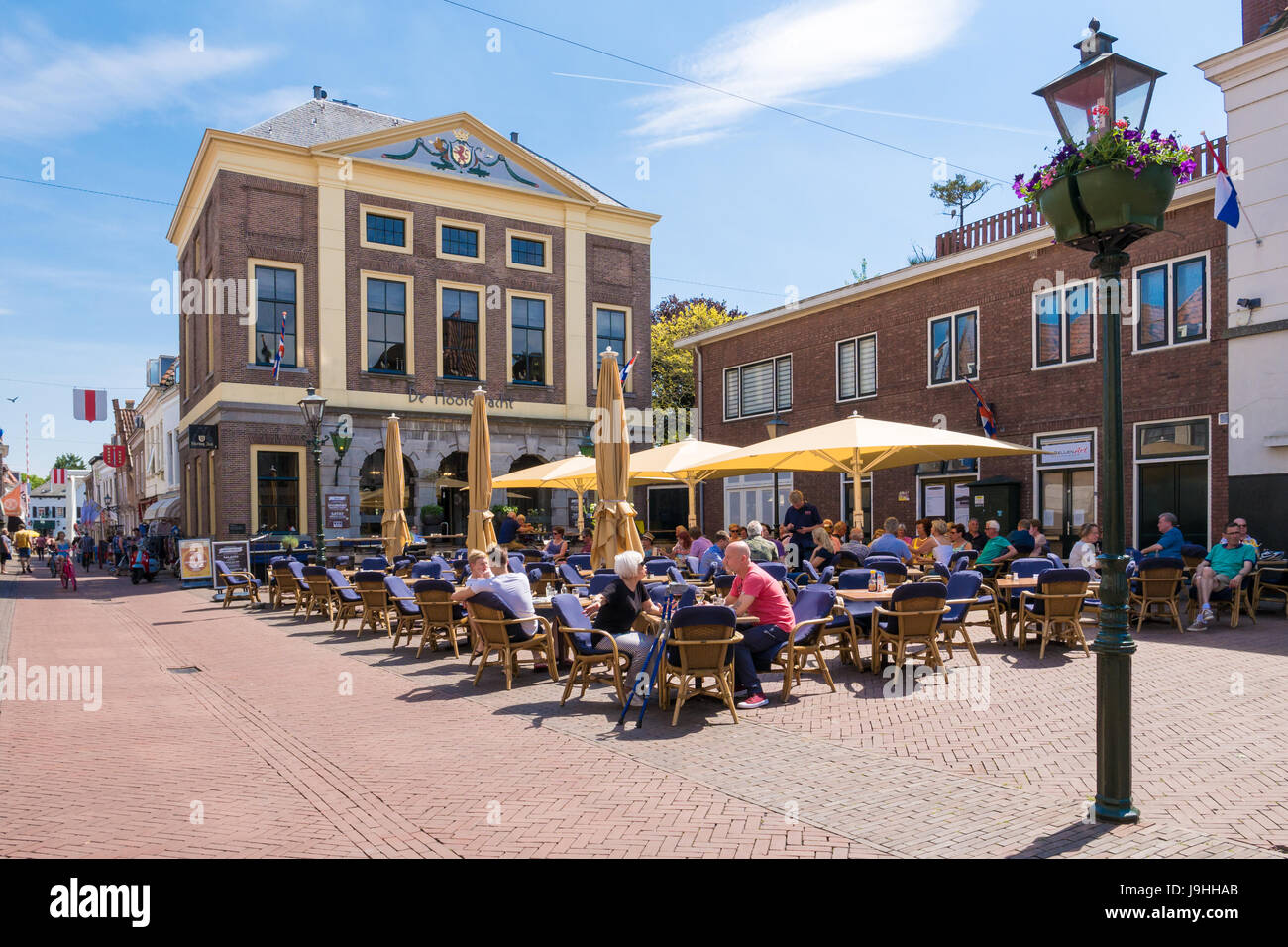 Persone presso la terrazza esterna del ristorante sulla piazza del mercato nella città vecchia di Brielle, South Holland, Paesi Bassi Foto Stock