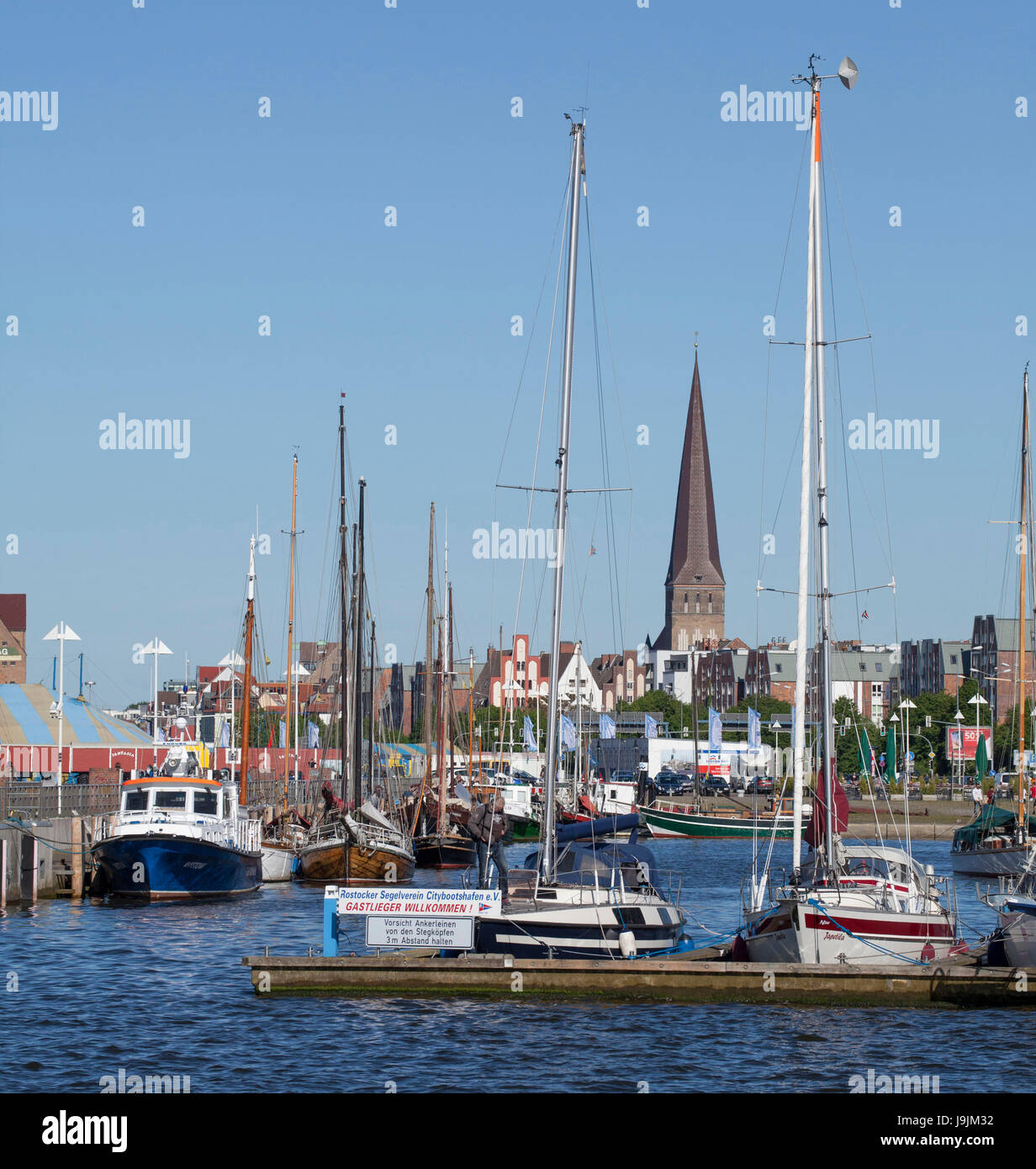L'Europa, Germania, Meclemburgo-Pomerania occidentale, Rostock, le navi nel porto cittadino con la Chiesa di San Pietro presso il cantiere Warnow Foto Stock