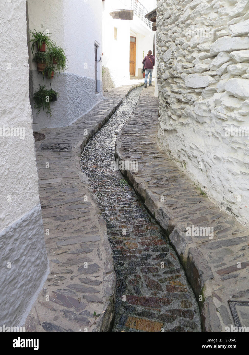 Aprire il tappo del foro di scarico nel mezzo della strada nel villaggio di Pampanaira, Andalusia, Spagna Foto Stock