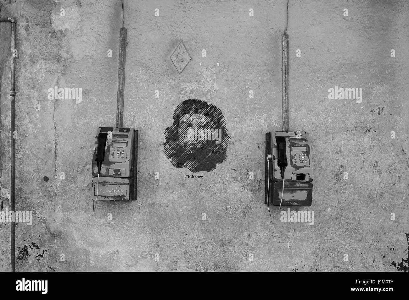 I telefoni a pagamento appeso alla parete con Ernesto Che Guevara stencil graffiti pittura a l'Avana, Cuba Foto Stock