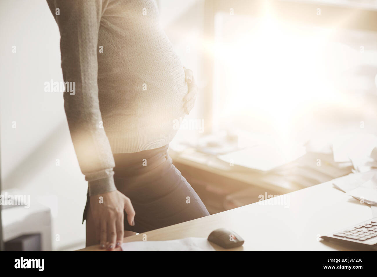 Imprenditrice incinta con il computer in ufficio Foto Stock