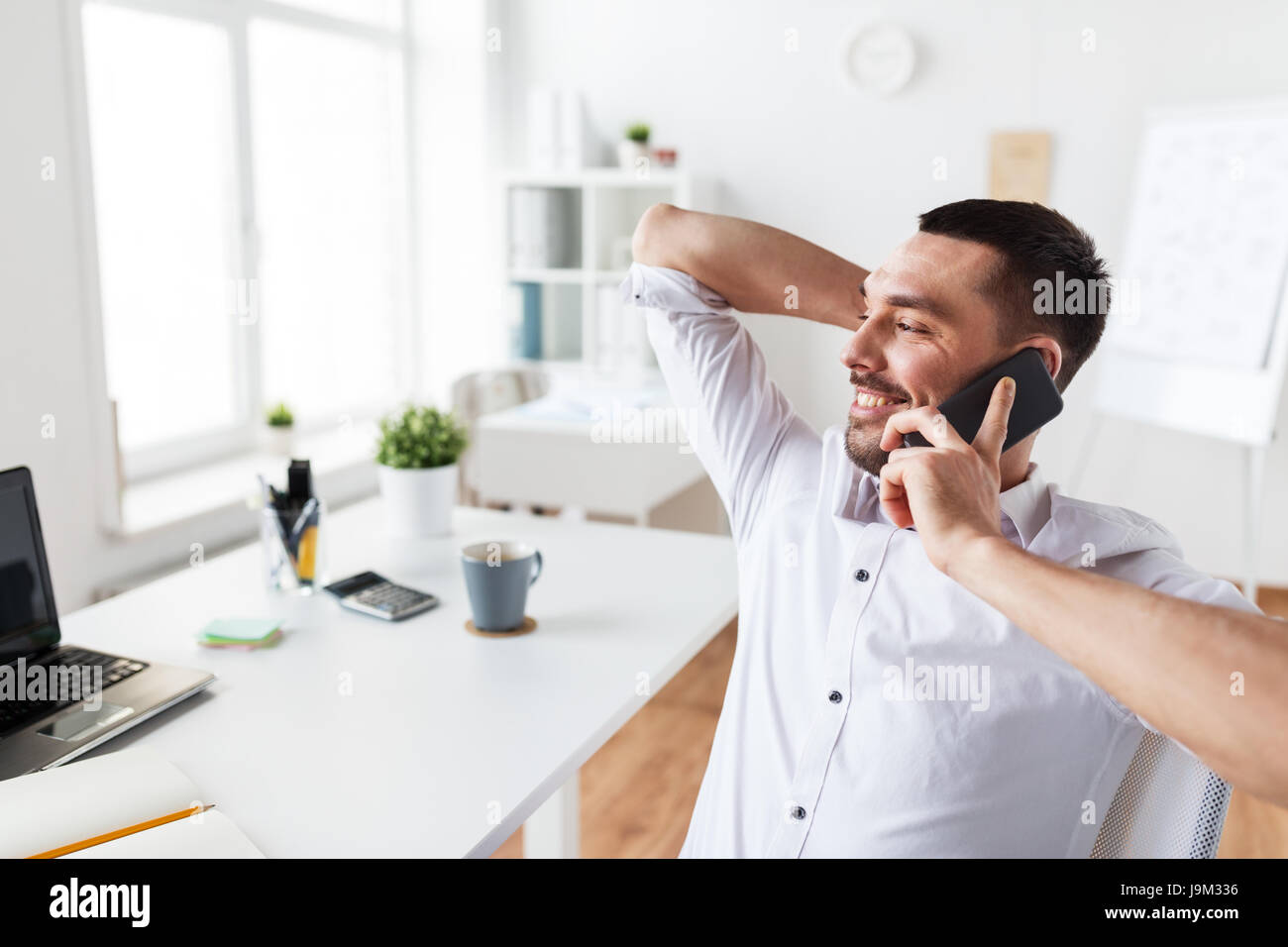 Imprenditore chiamando sullo smartphone in ufficio Foto Stock